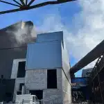 Usine moderne avec cheminées et structure métallique.