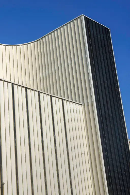 Immeuble moderne avec façade en métal ondulé.