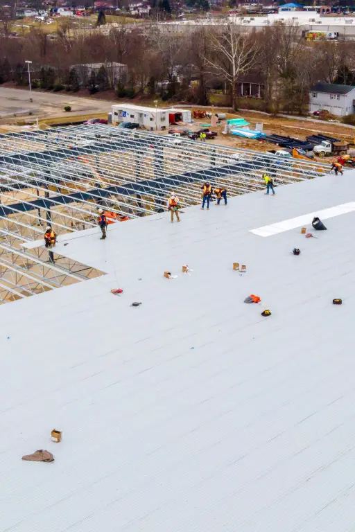 etancheite toit batiment industriel Travailleurs sur un toit en construction